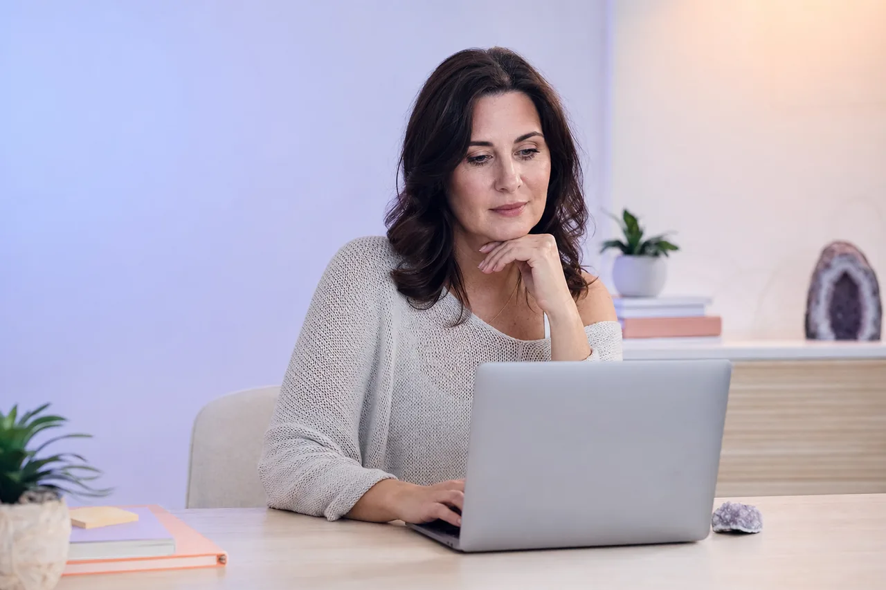 A woman researching at her laptop in a calm home office