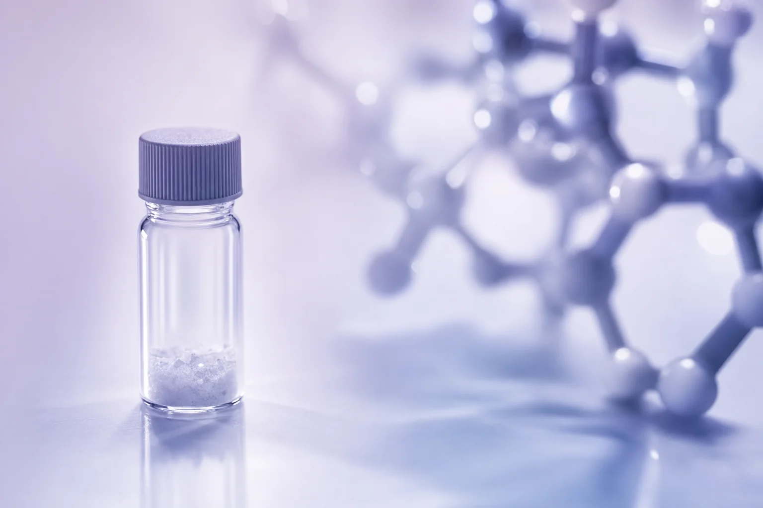A glass vial beside a blurred molecular fragment diagram on a near-white surface with lavender light