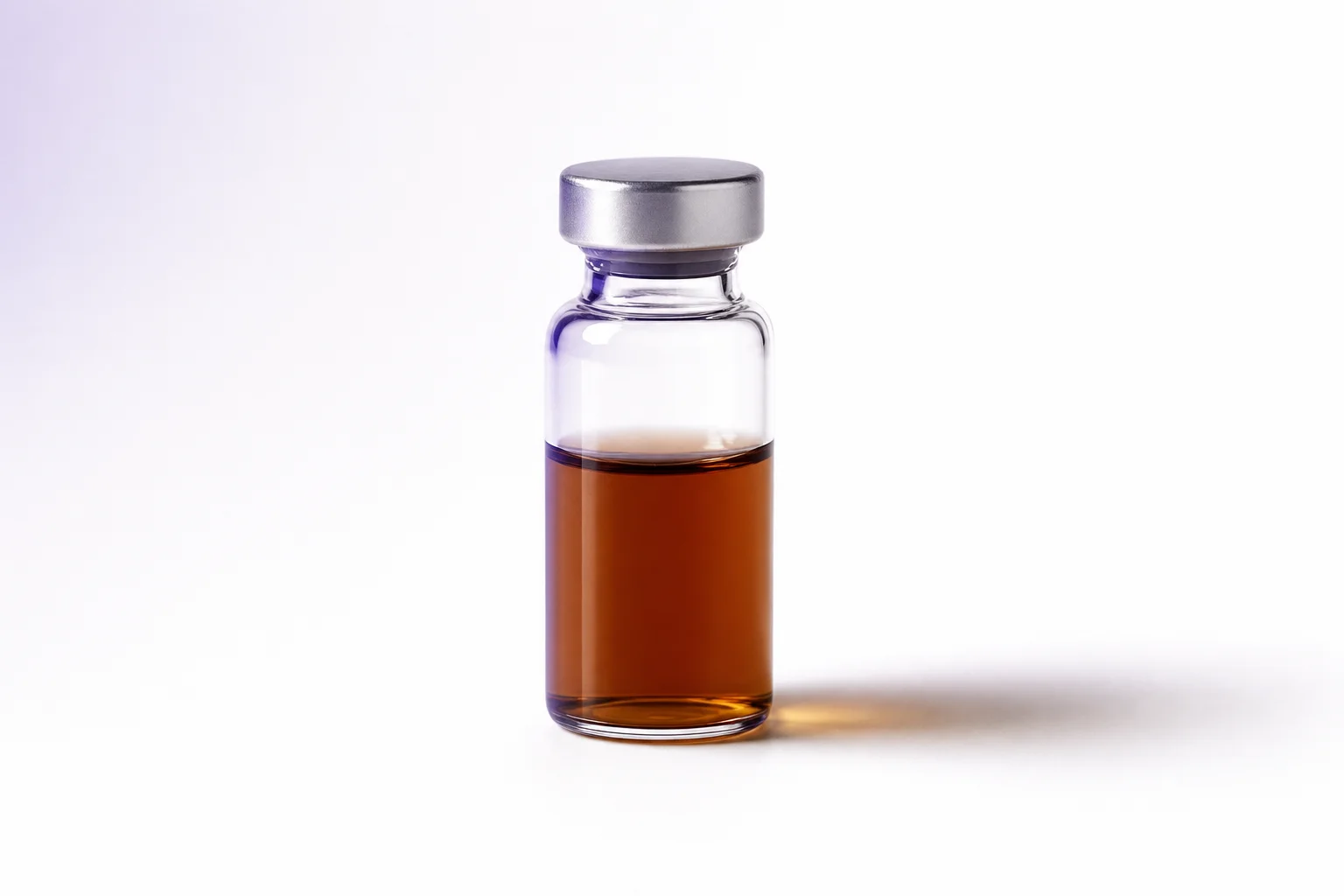 A glass vial on a near-white surface with a subtle tawny gradient shadow evoking melanin pigmentation research