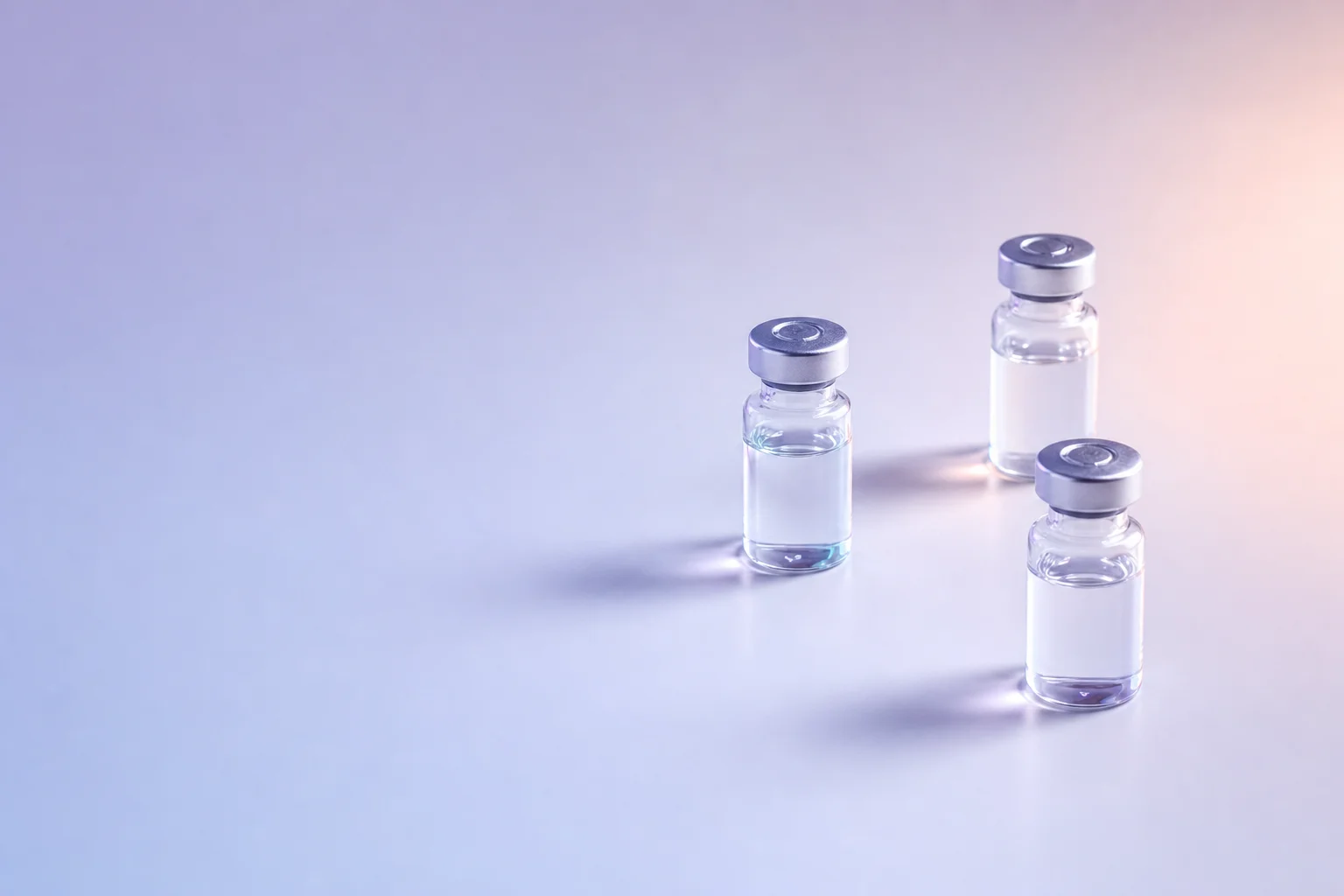 Three glass vials in a loose triangle on a near-white surface, suggesting a triple receptor mechanism